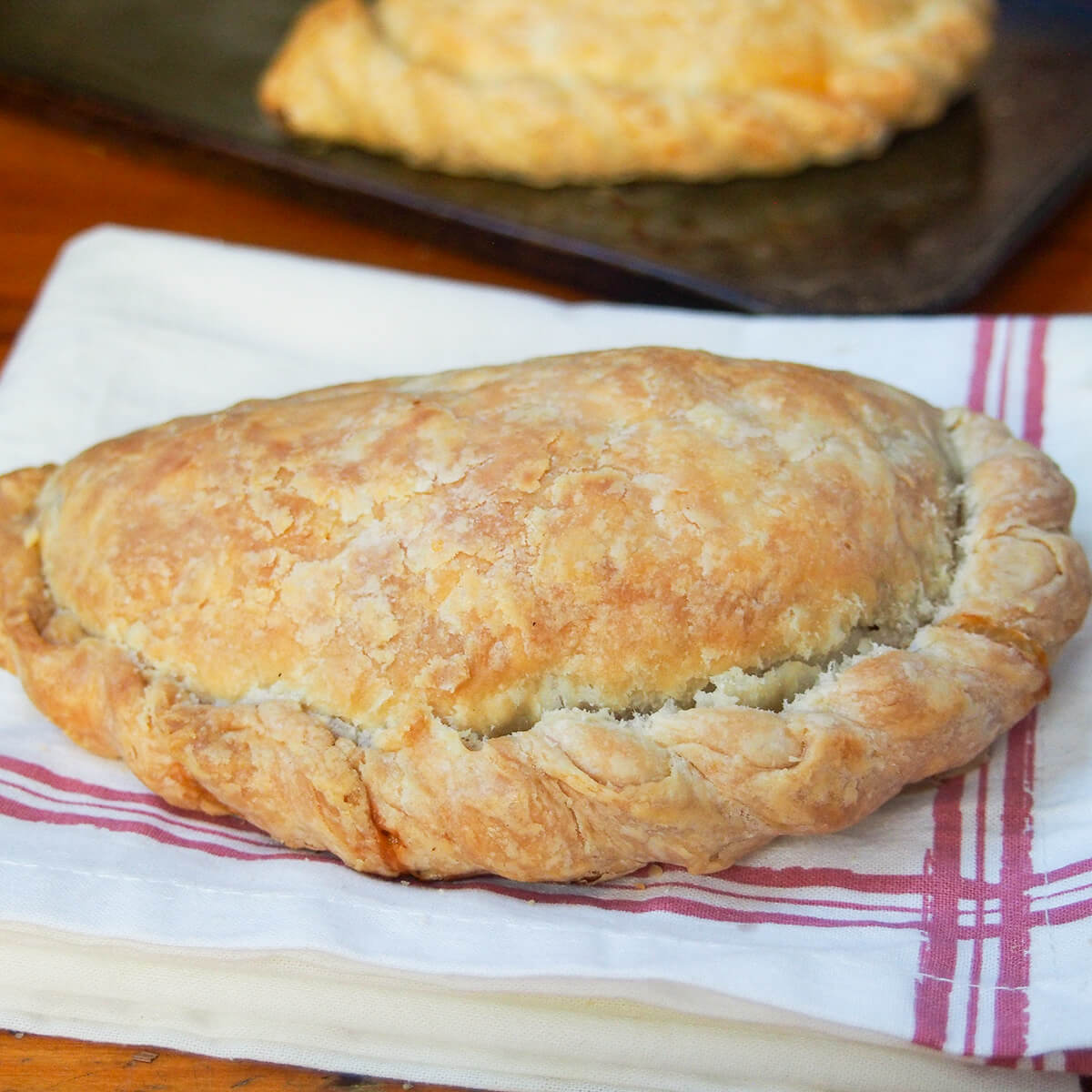whole Cornish pasty on white kitchen towel.