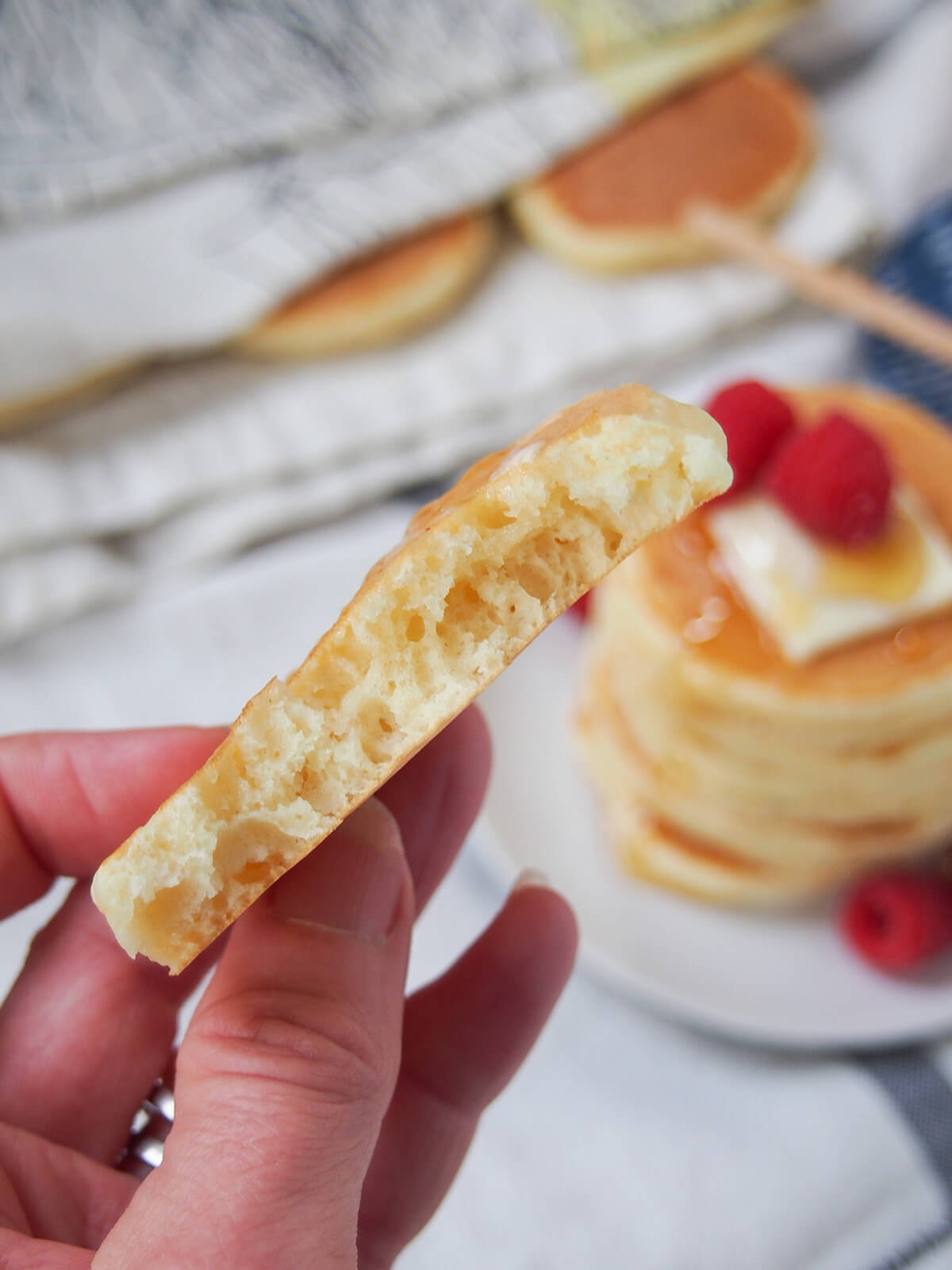 holding a torn Scotch pancake in hand showing air pockets inside.
