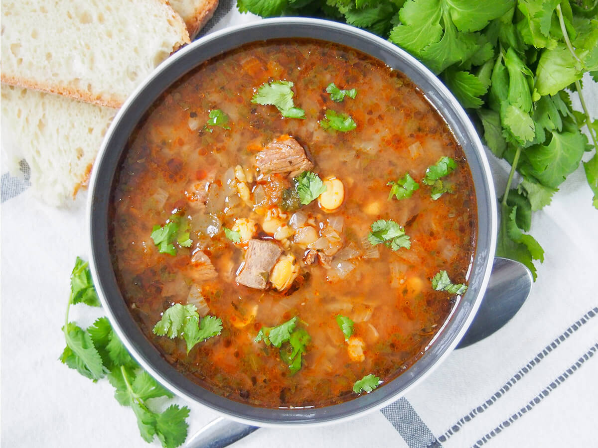 bowl of chorba frik with spoon under bowl.