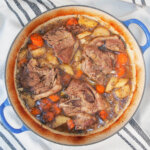 braised lamb shoulder chops and vegetables in dish.