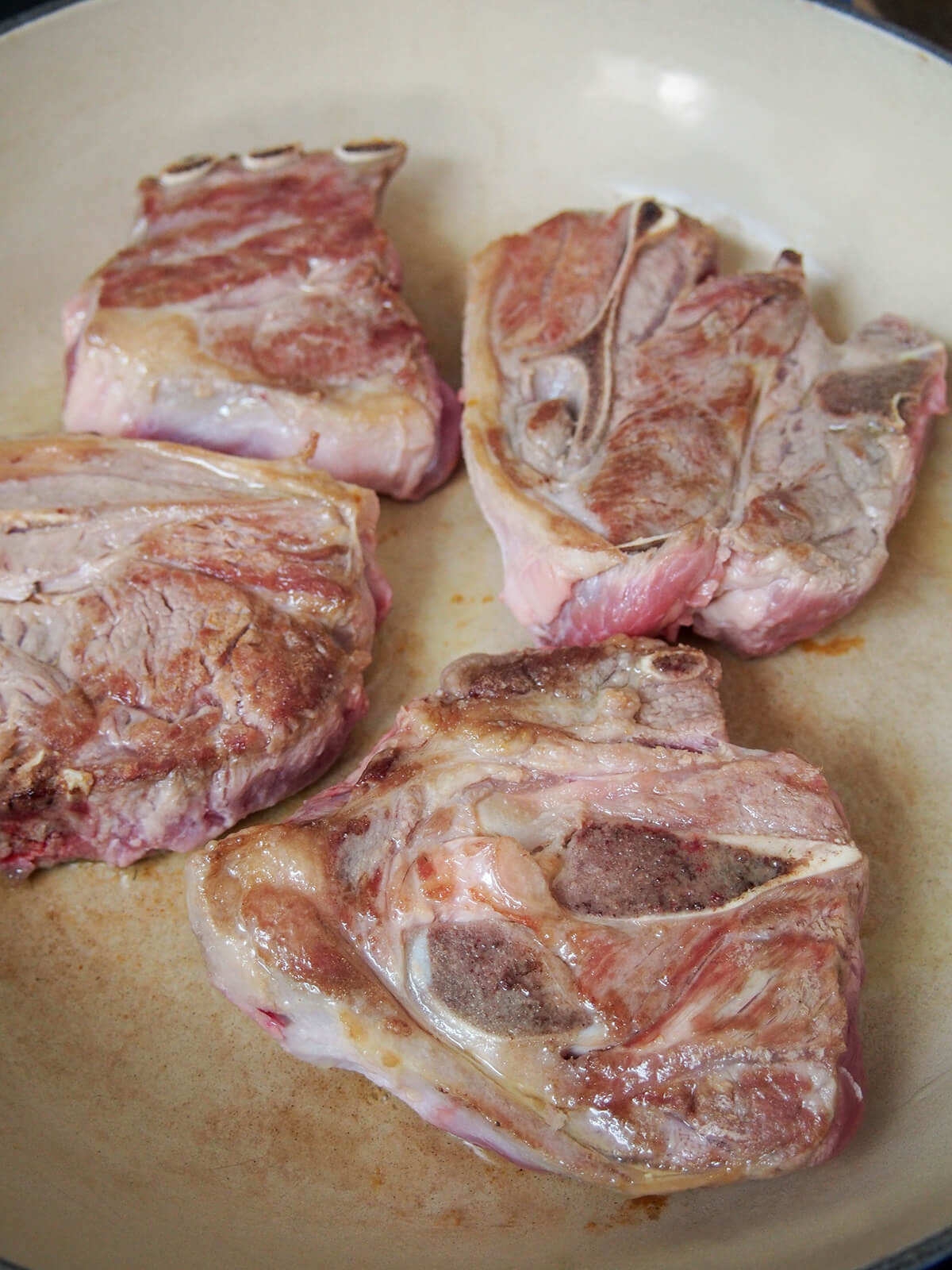 browning lamb chops in wide dish.