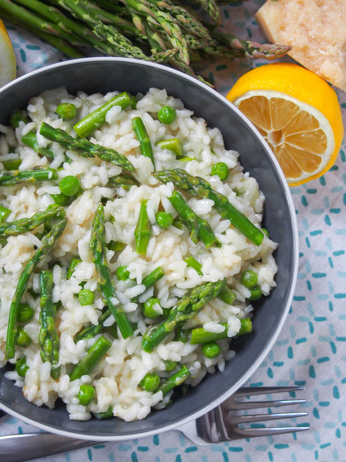 overhead view of lemon asparagus risotto with fork below bowl.
