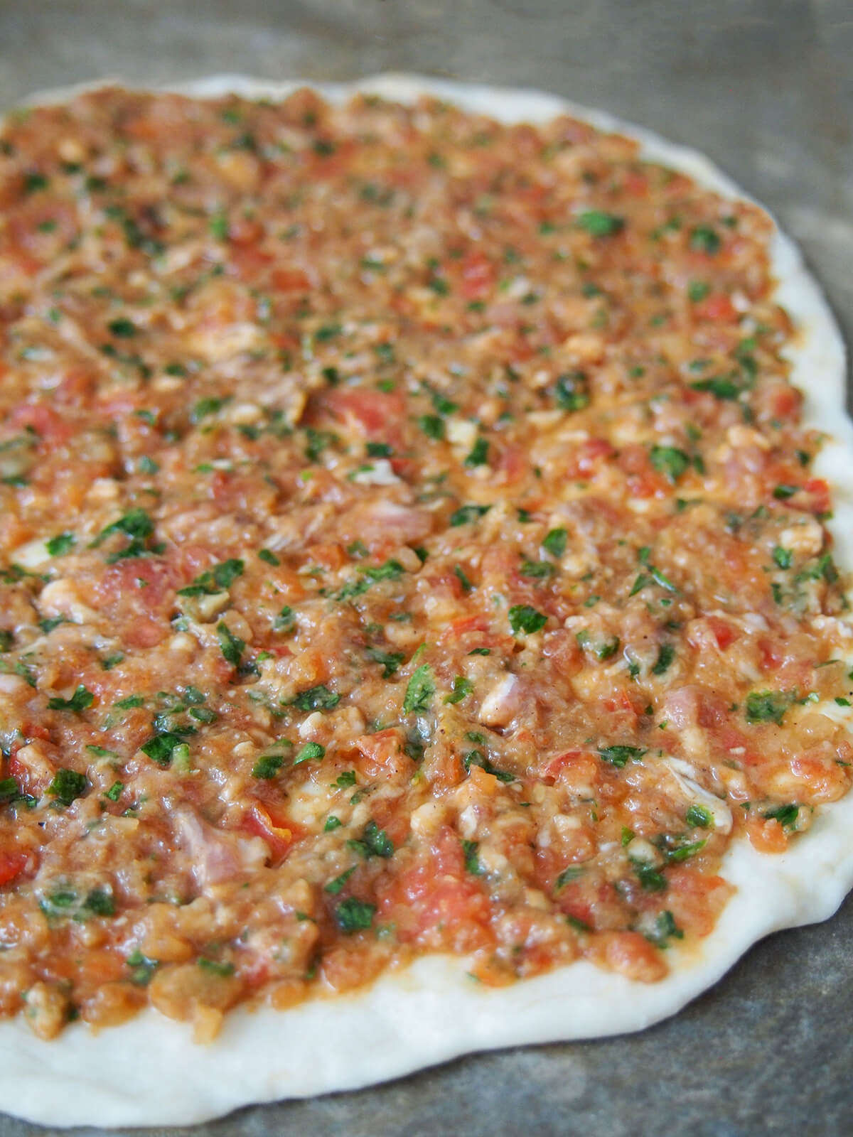 thin meat topping over top of dough before cooking.