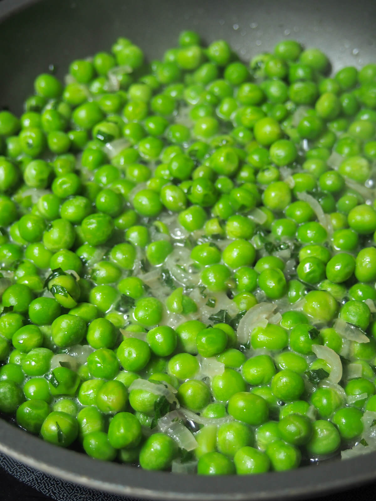 simmering minted peas in skillet.