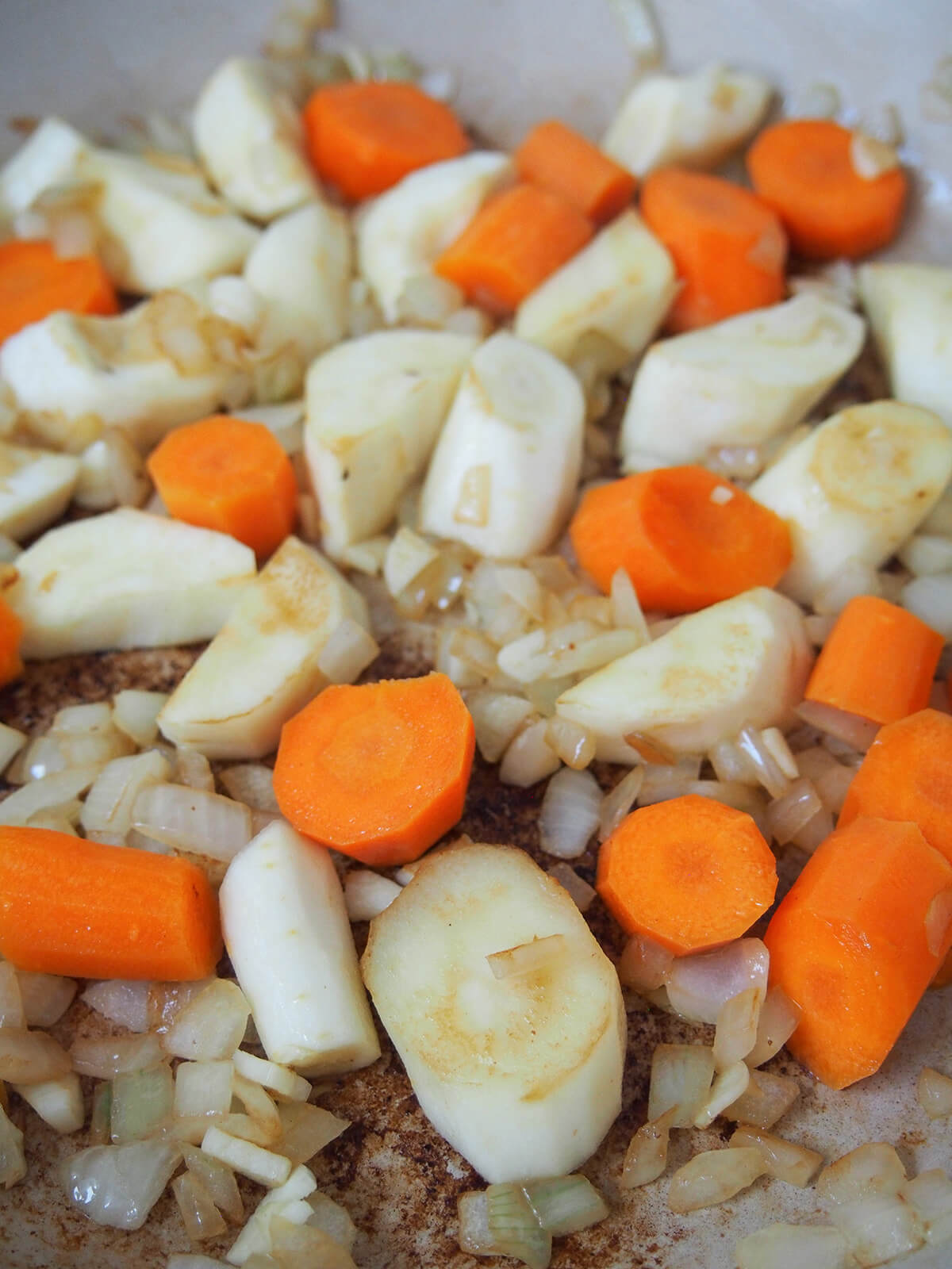 pre cooking onions, carrot and parsnip in dish.