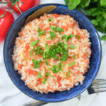close up view of Portuguese tomato rice in blue bowl.