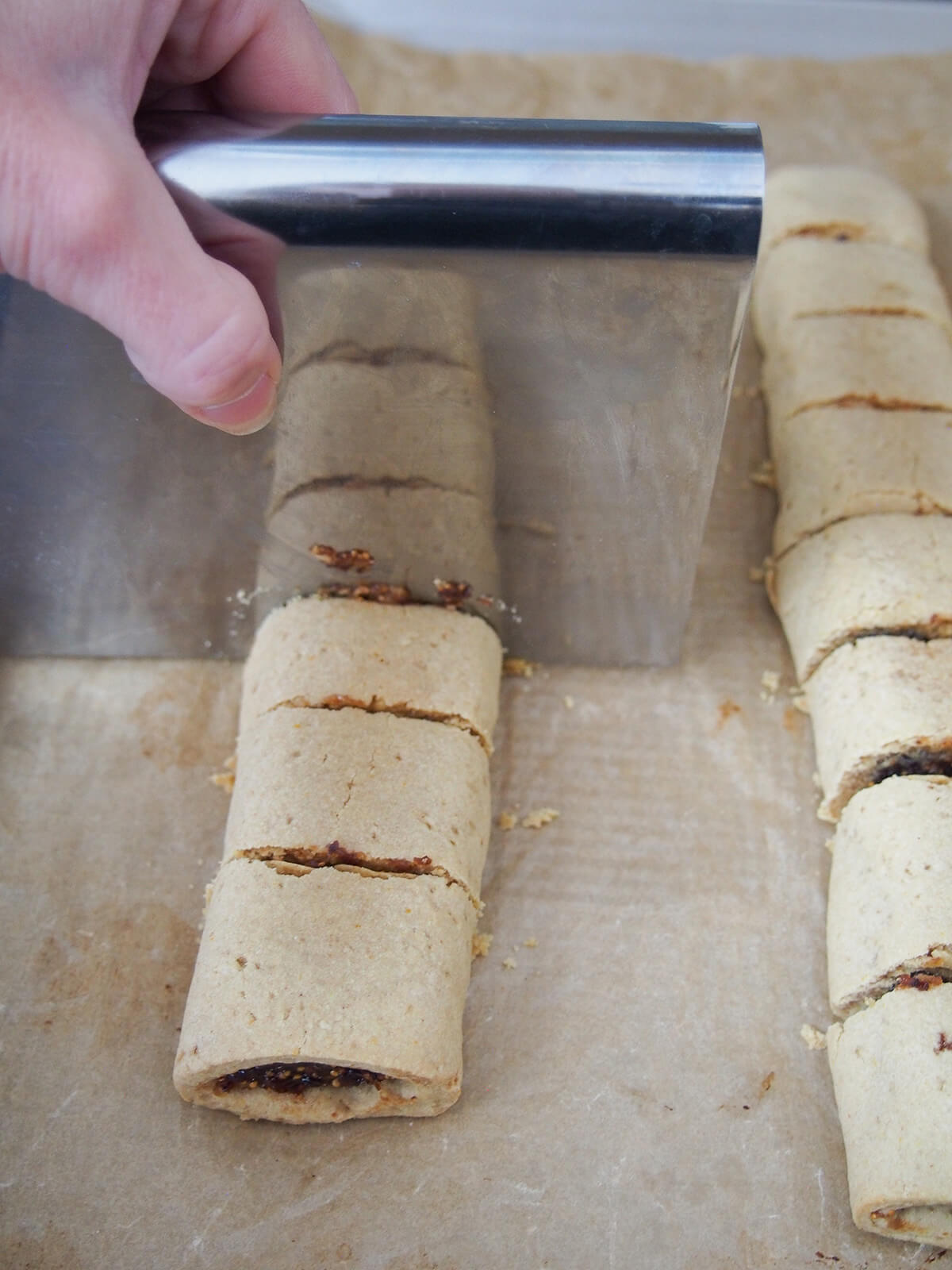 cutting baked homemade fig Newtons into pieces.