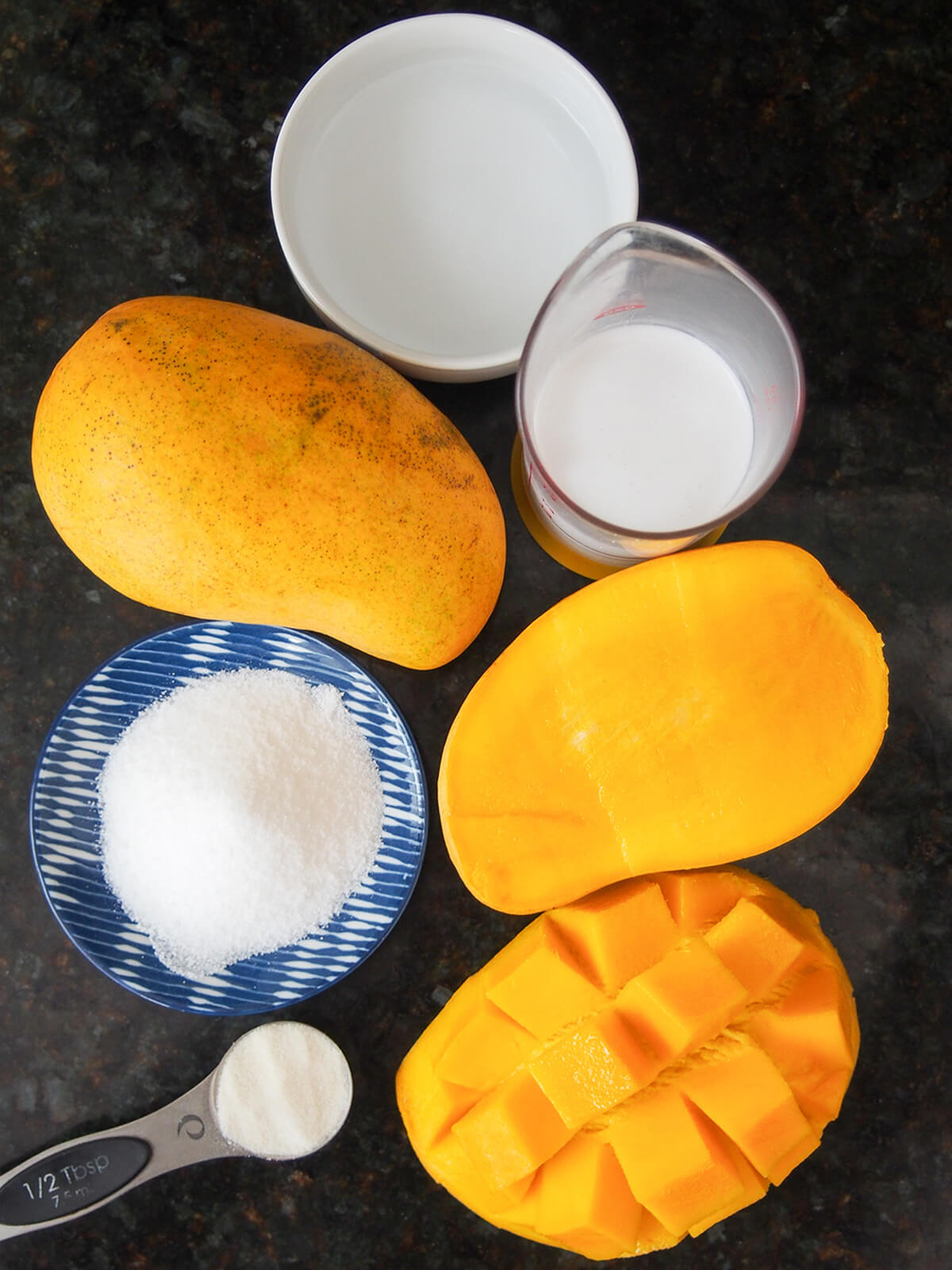 whole and cut mango, bowl with water, place of sugar and measure with coonut milk all from overhead.