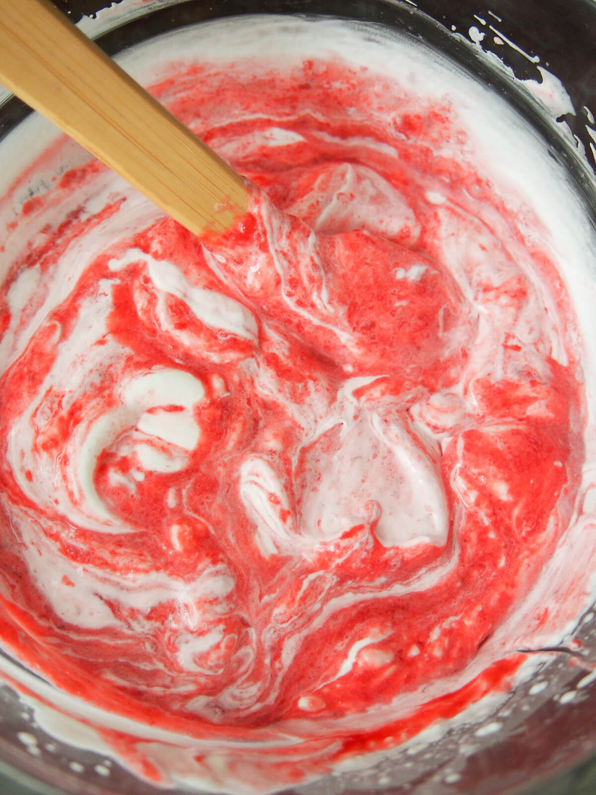 swirling raspberry puree into cream.