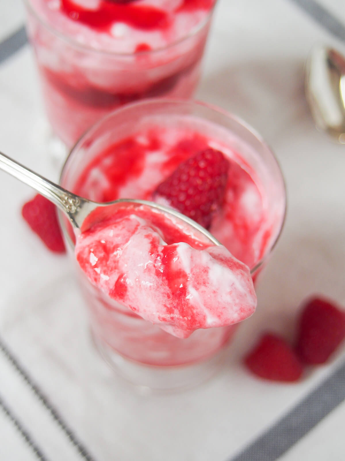 spoonful of raspberry fool held above glass