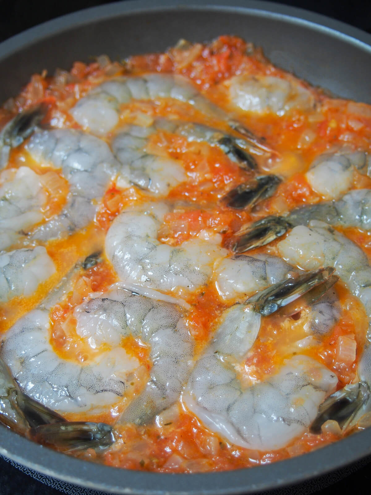 raw shrimp nestled in tomato sauce.