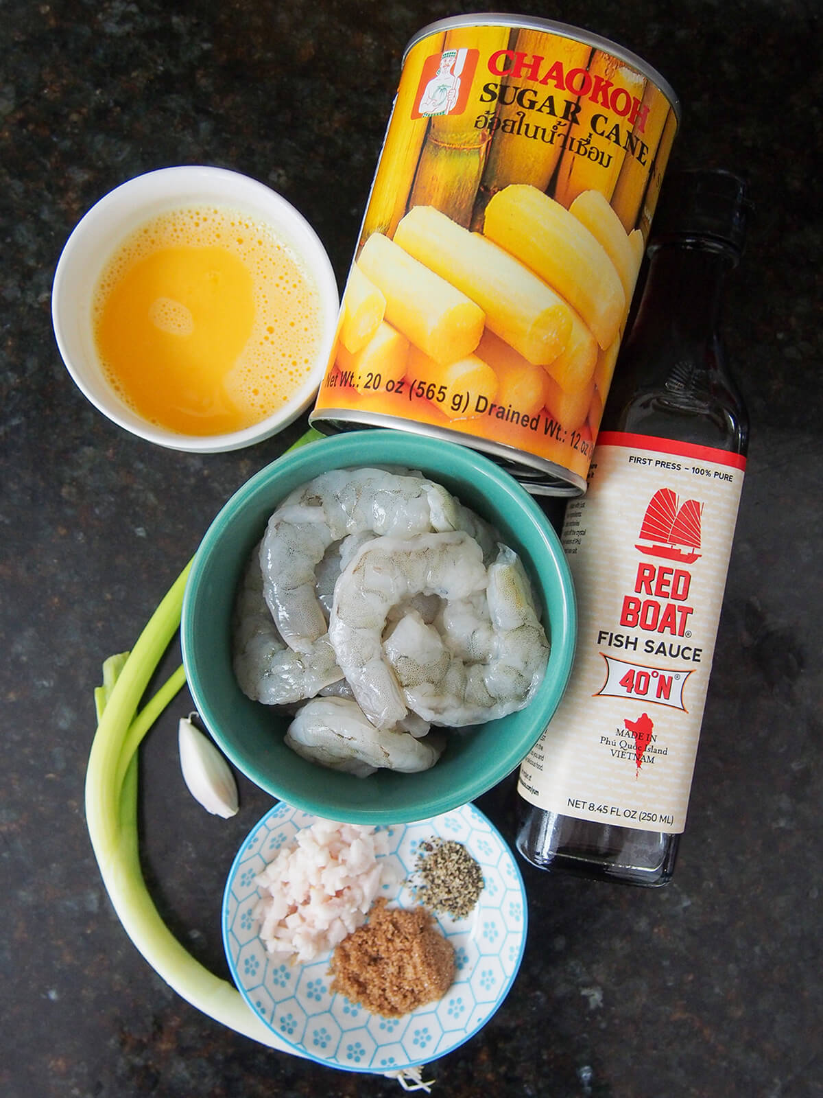 can of sugar cane, bowls of egg and shrimp, fish sauce and small plate with pork fat, pepper and sugar.