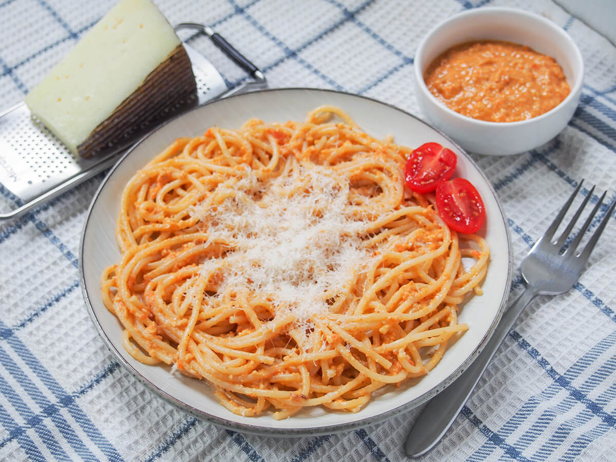 side view of plate of romesco pasta with fork to right of plate.