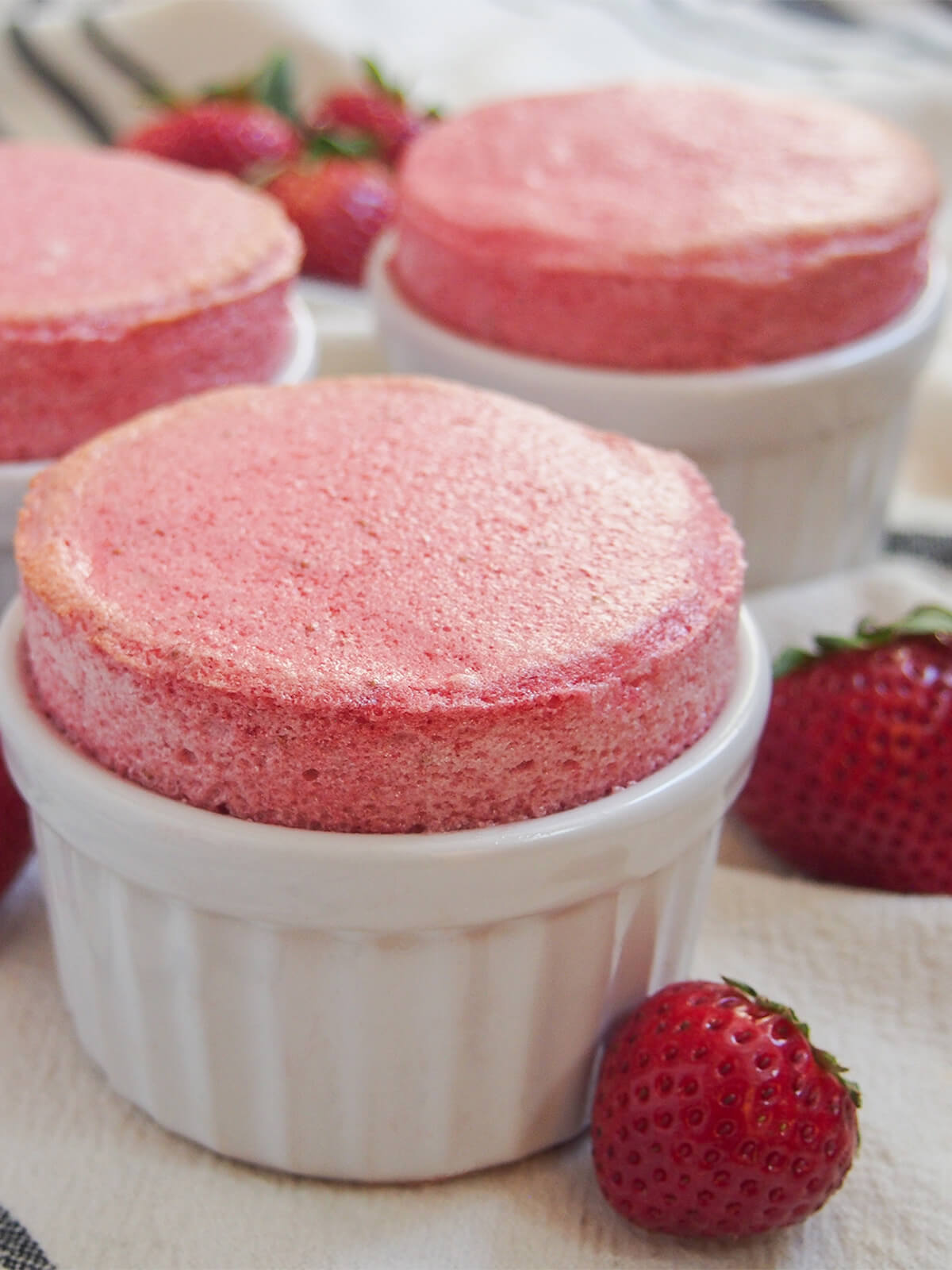 close view of a strawberry souffle with others in part view behind.