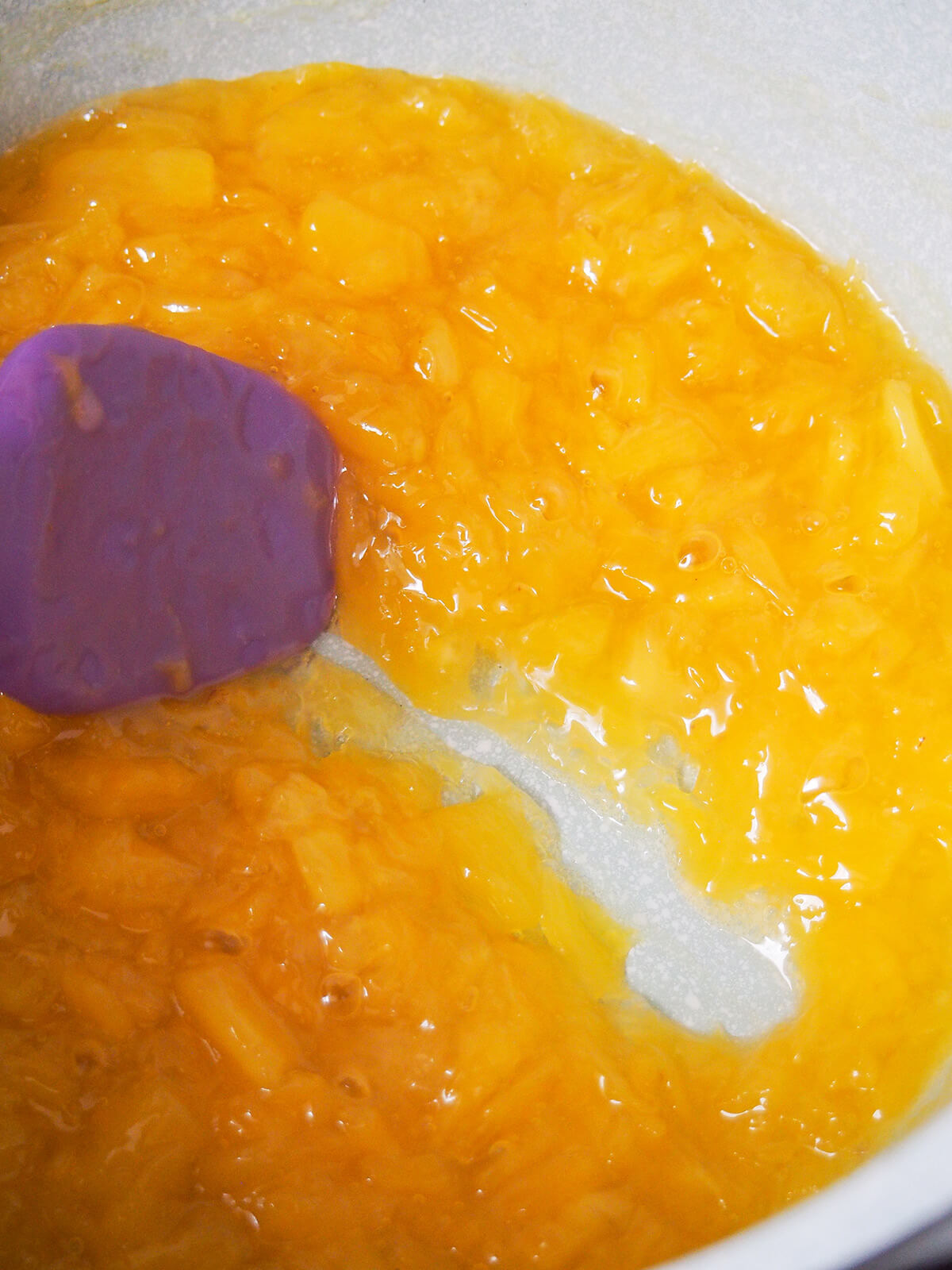 moving spatula through pineapple filling mixture as it's thickening.