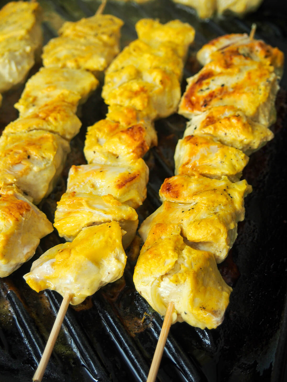 cooking skewers of jujeh kabab.