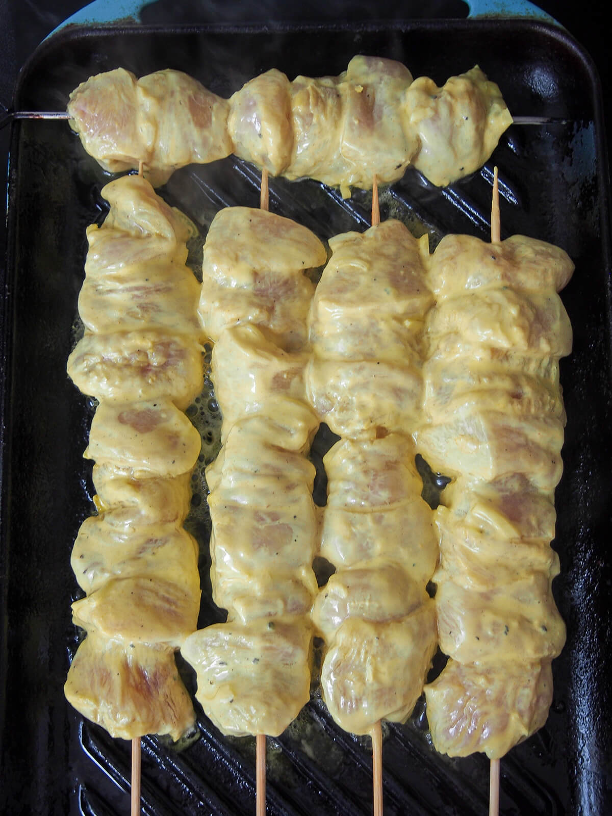 skewers starting to cook on grill.