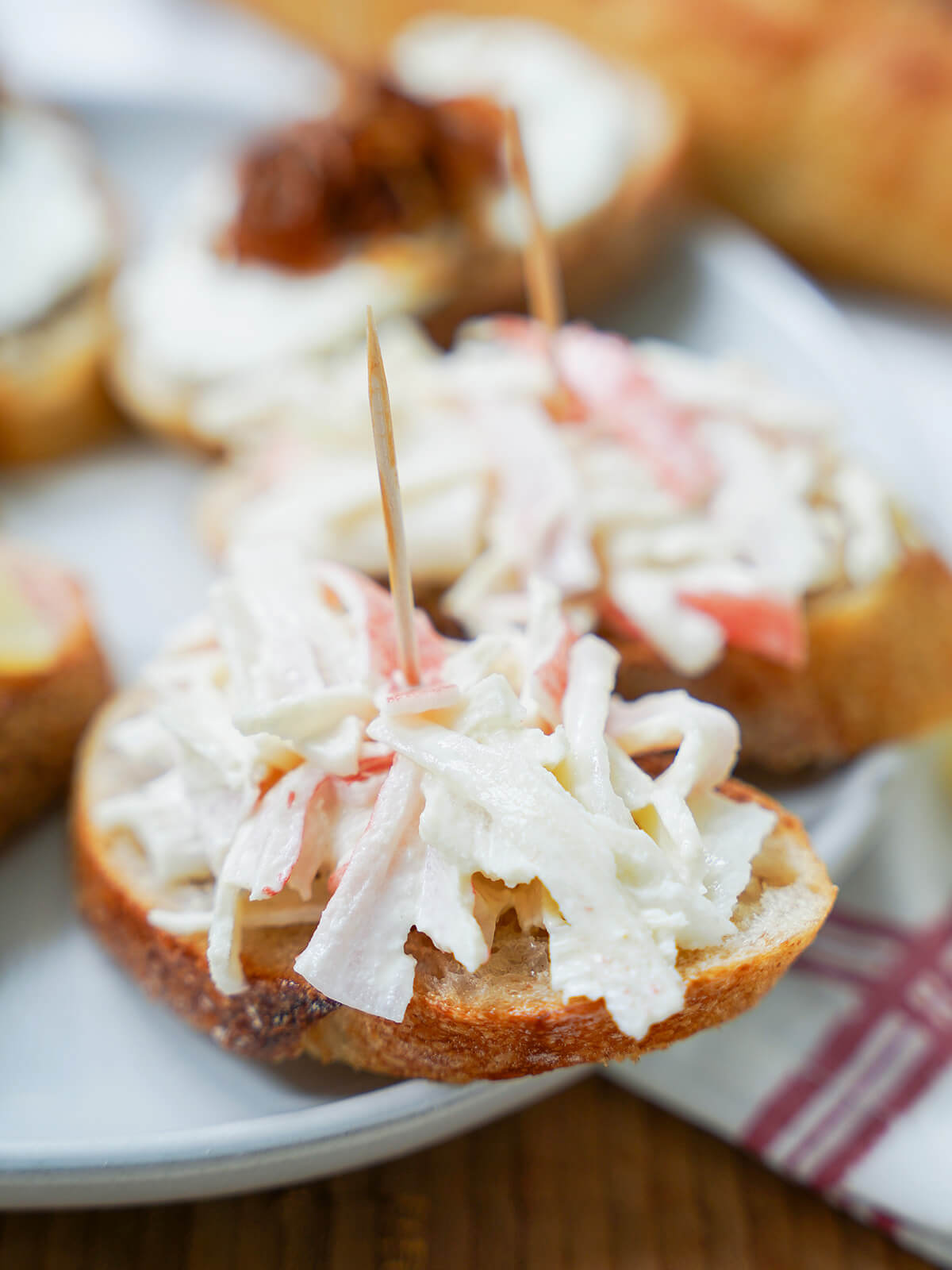 imitation crab, txaka pintxo, one of many easy Spanish pintxos recipes close up view of imitation crab pintxo with cocktail stick on topping.