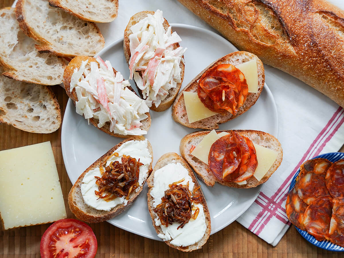 Spanish pintxos recipes overhead view of plate with six Spanish pintxos, two each of three different kinds,