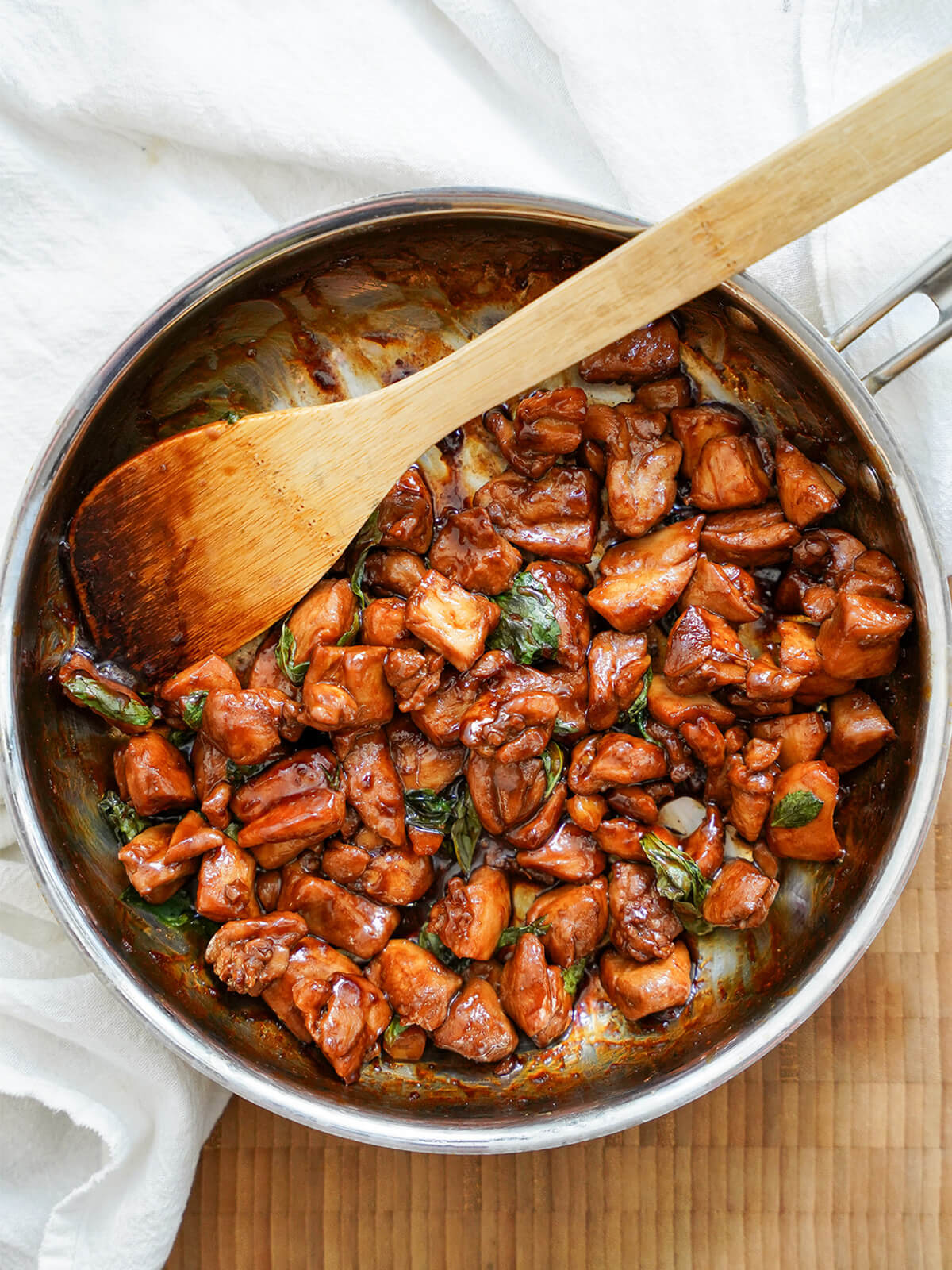 Taiwanese three cup chicken (san bei ji) is a tasty, comforting dish that's quick to make. With a great balance of flavors, and not too many ingredients, it's perfect for an easy weeknight meal. skillet of Taiwanese three cup chicken with spatula to side.