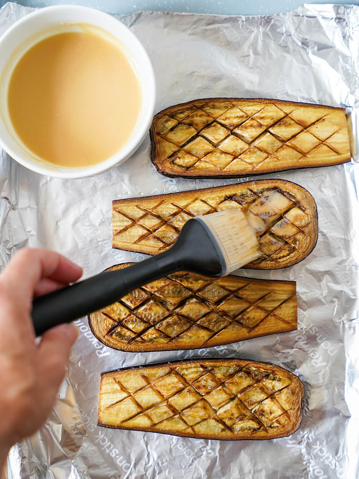 brushing roasted eggplant halves with miso glaze