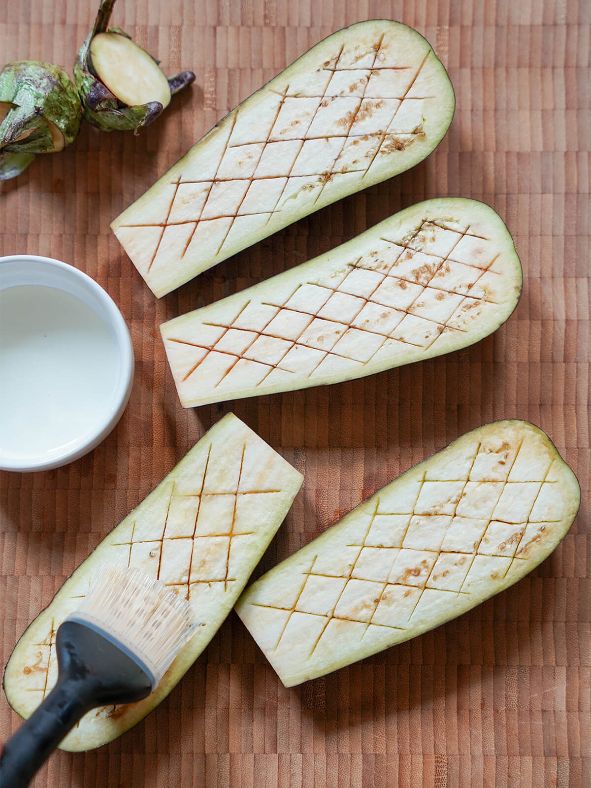 brushing scored half eggplants with oil before roasting.