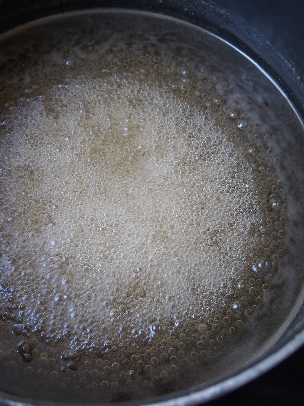 simmering jelly liquid in pot.