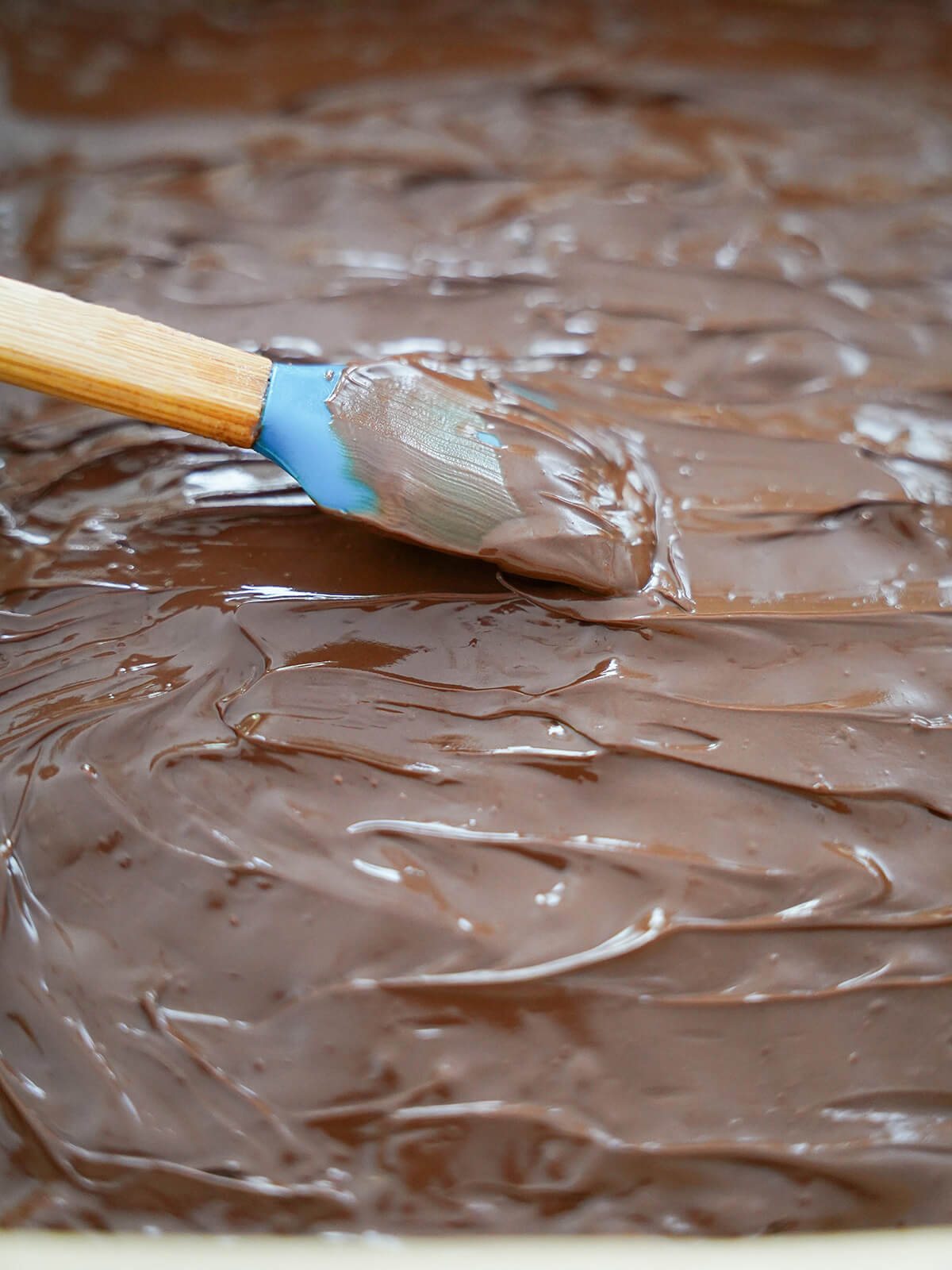 spreading chocolate over surface with a spatula.