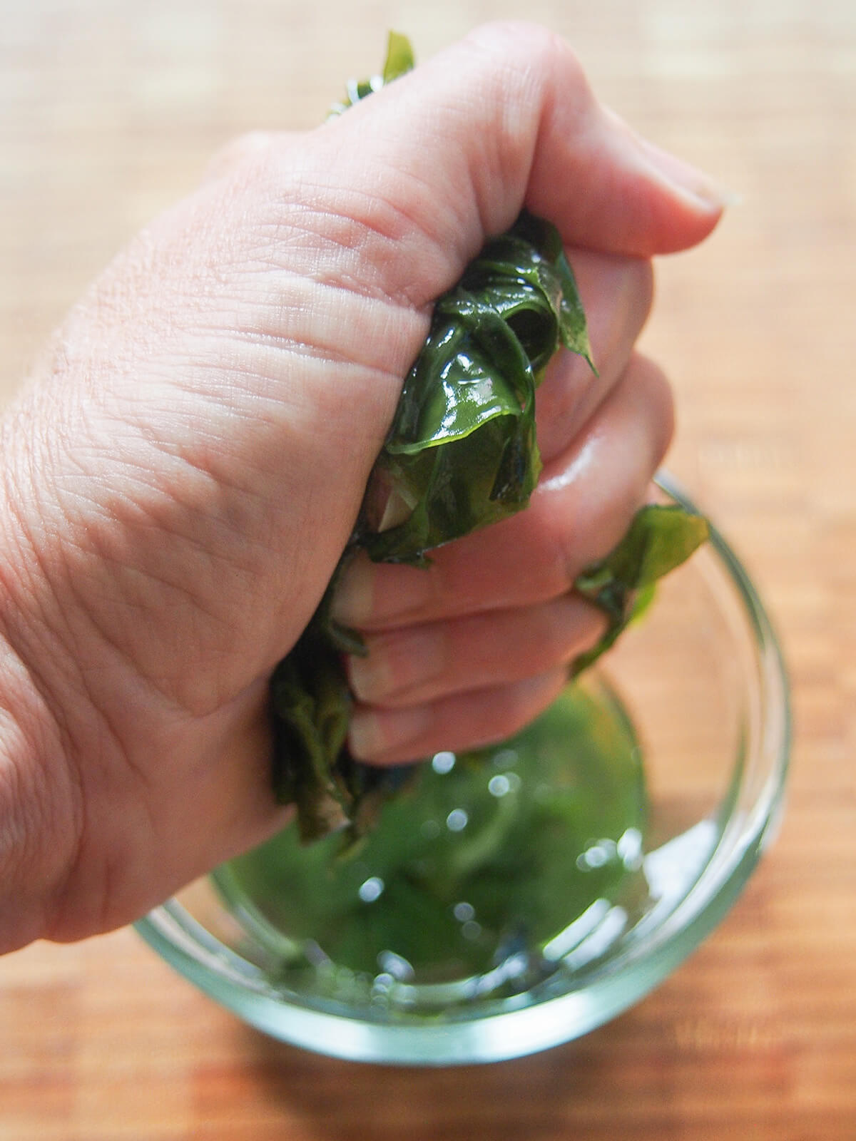 squeezing liquid from rehydrated wakame seaweed