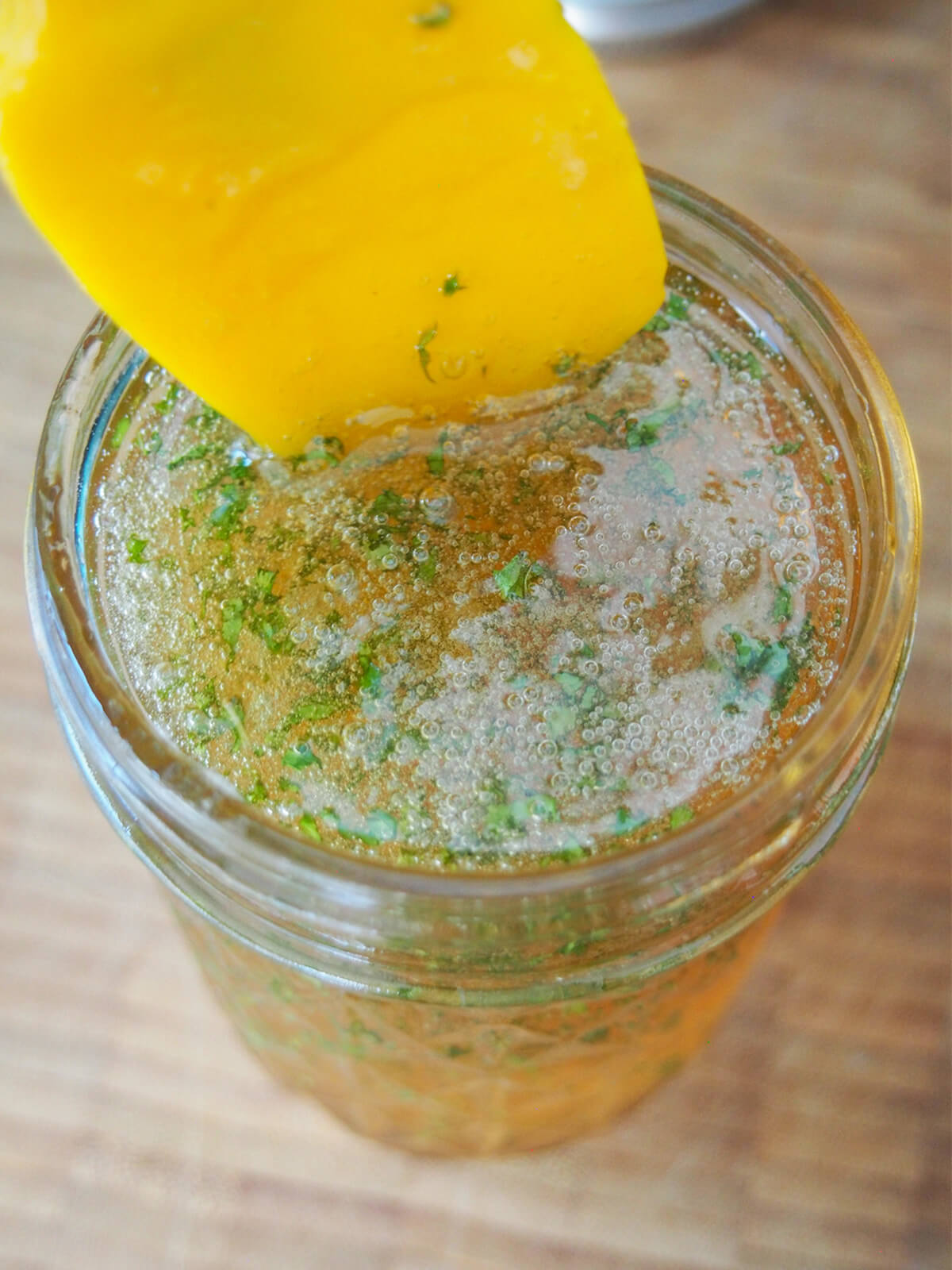 stirring pieces of finely chopped mint into jar of jelly.