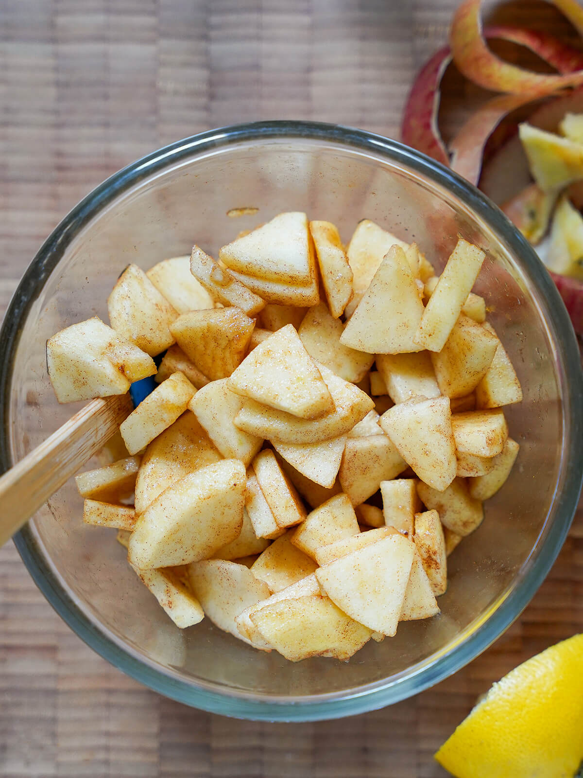 apple slices tossed with cinnamon and sugar apple slices tossed with sugar and cinnamon in bowl.