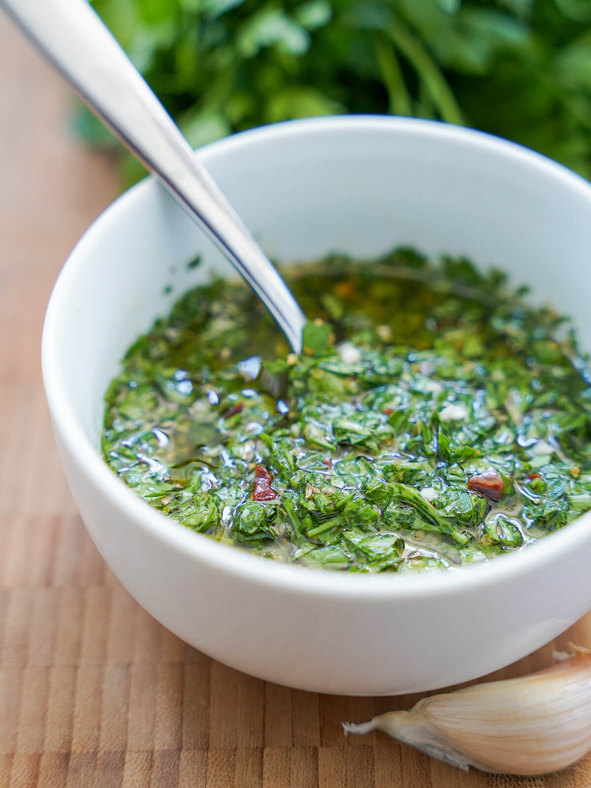 bowl of chimichurri sauce with spoon in it.