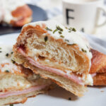 Croque monsieur croissant cut in half close up.
