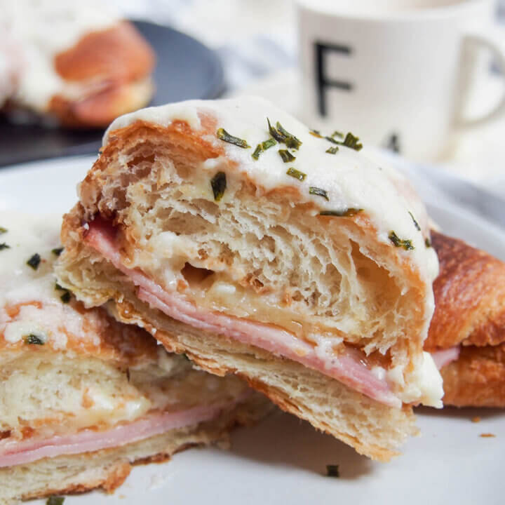 Croque monsieur croissant cut in half close up.