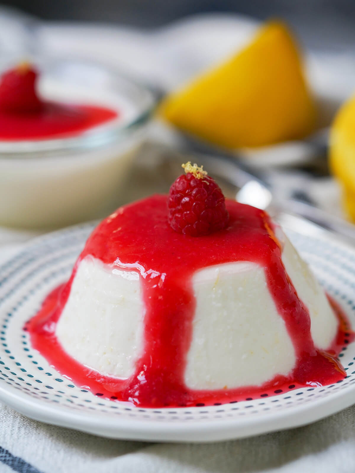 lemon panna cotta close up with raspberry coulis over top.