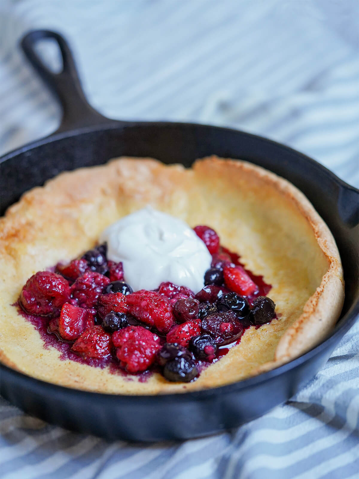 side close view of Individual Dutch baby pancake with berries.