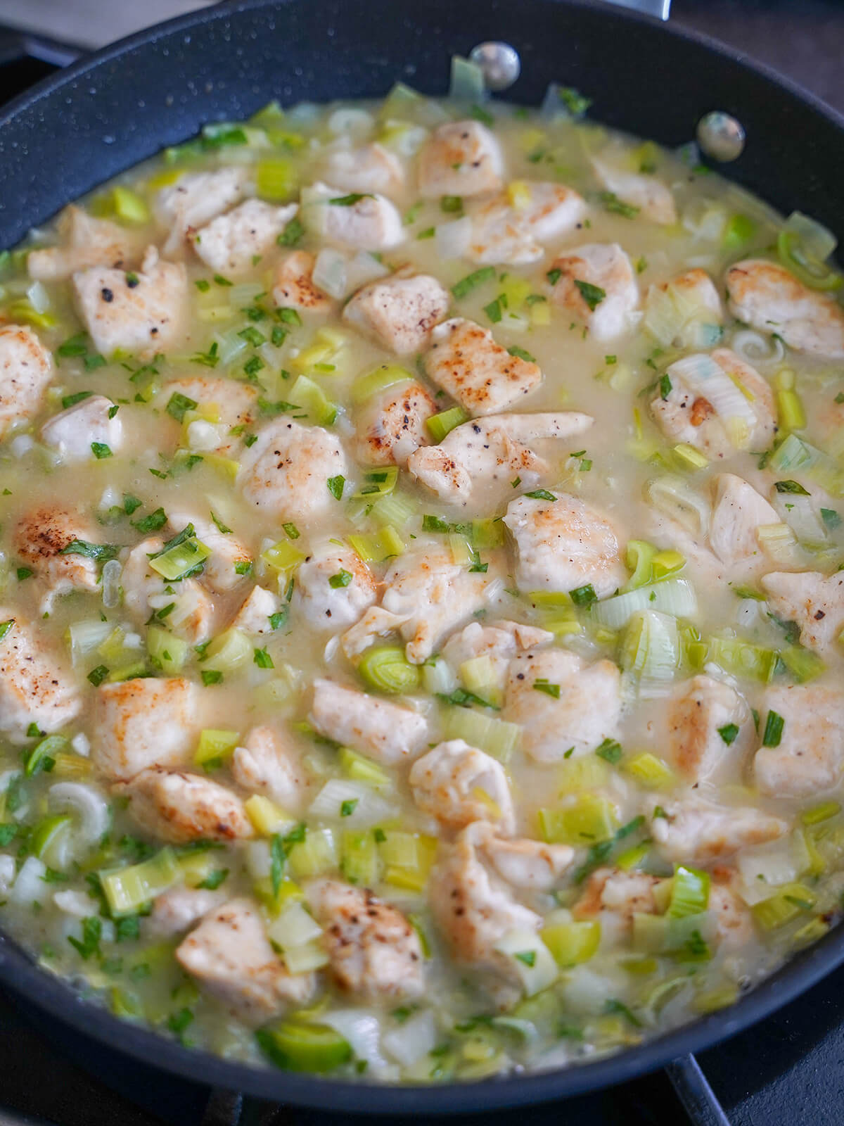chicken and leek sauce mixture in pan.