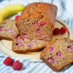 part loaf of raspberry banana bread with slices either side.