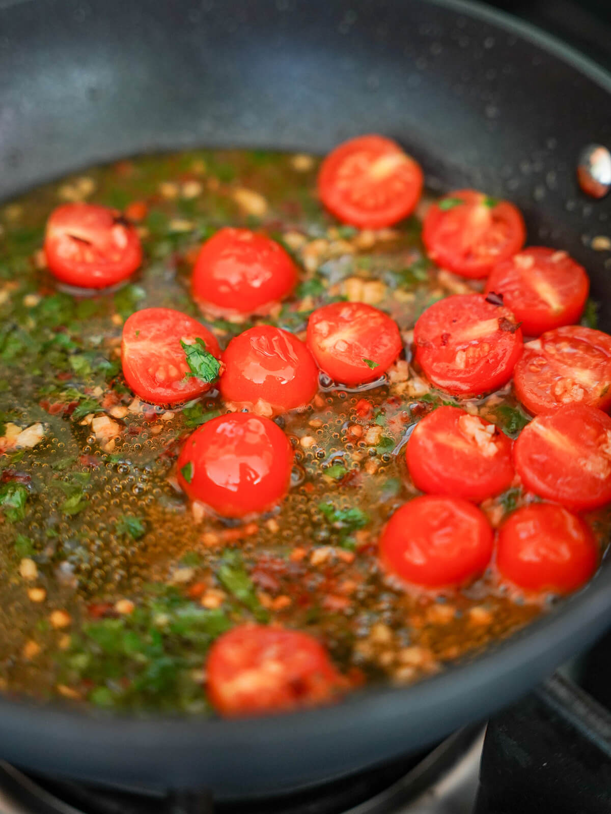 cut cherry tomatoes in skillet with garlic, parsley, red pepper, oil and wine.