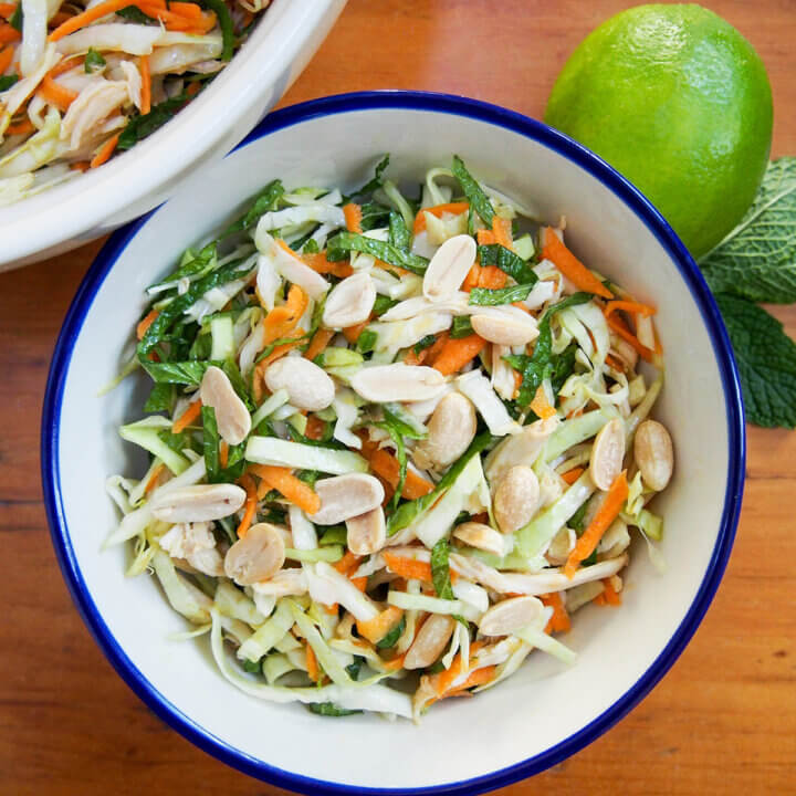 overhead view of a bowl of Vietnamese chicken salad with lime to side.