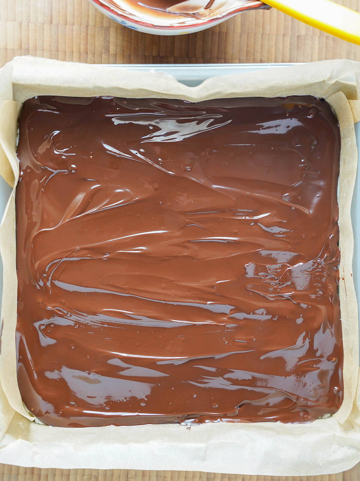 melted chocolate over other layers in lined tin.