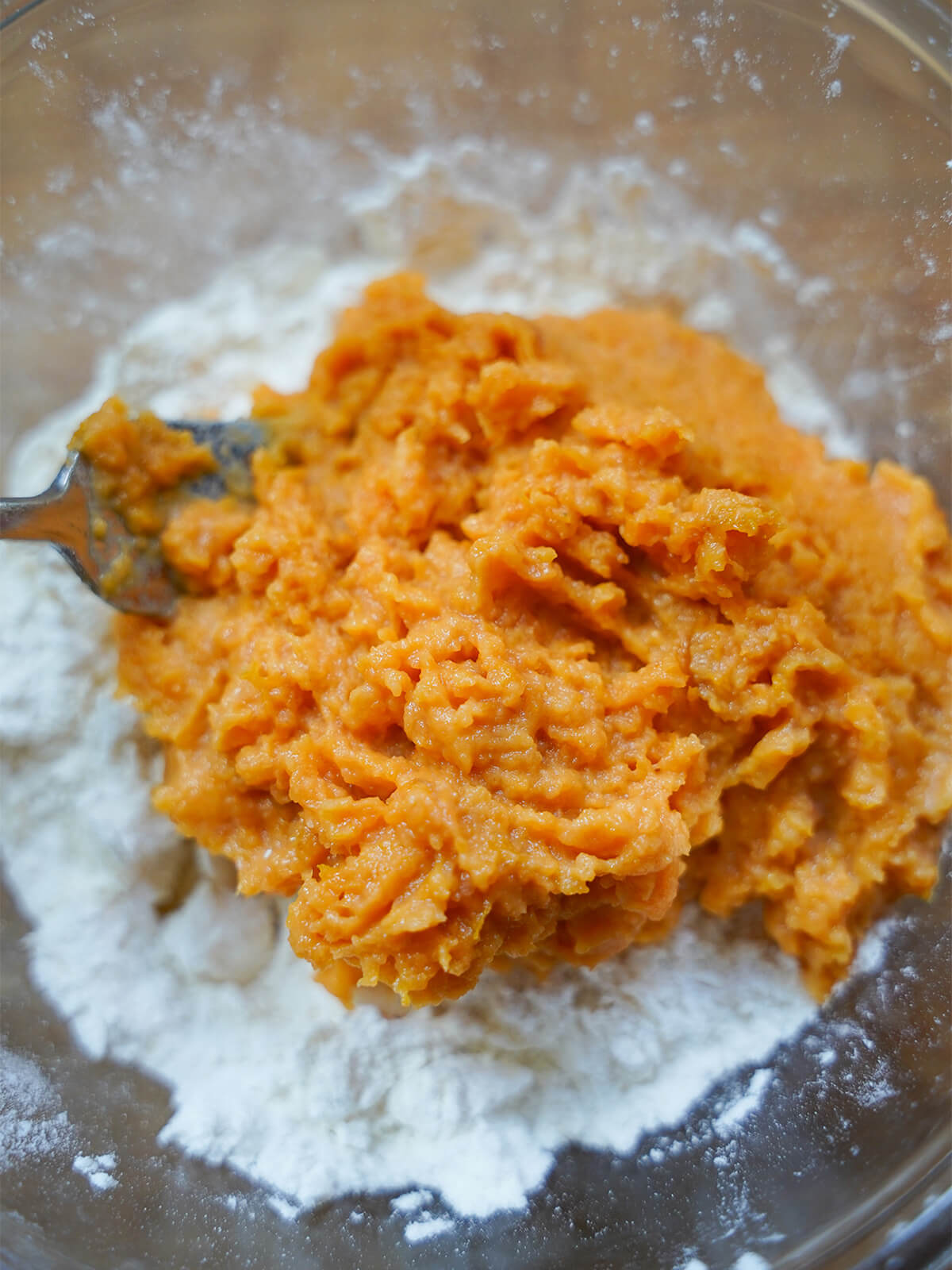 sweet potato mixture on top of flour mixture in a bowl.