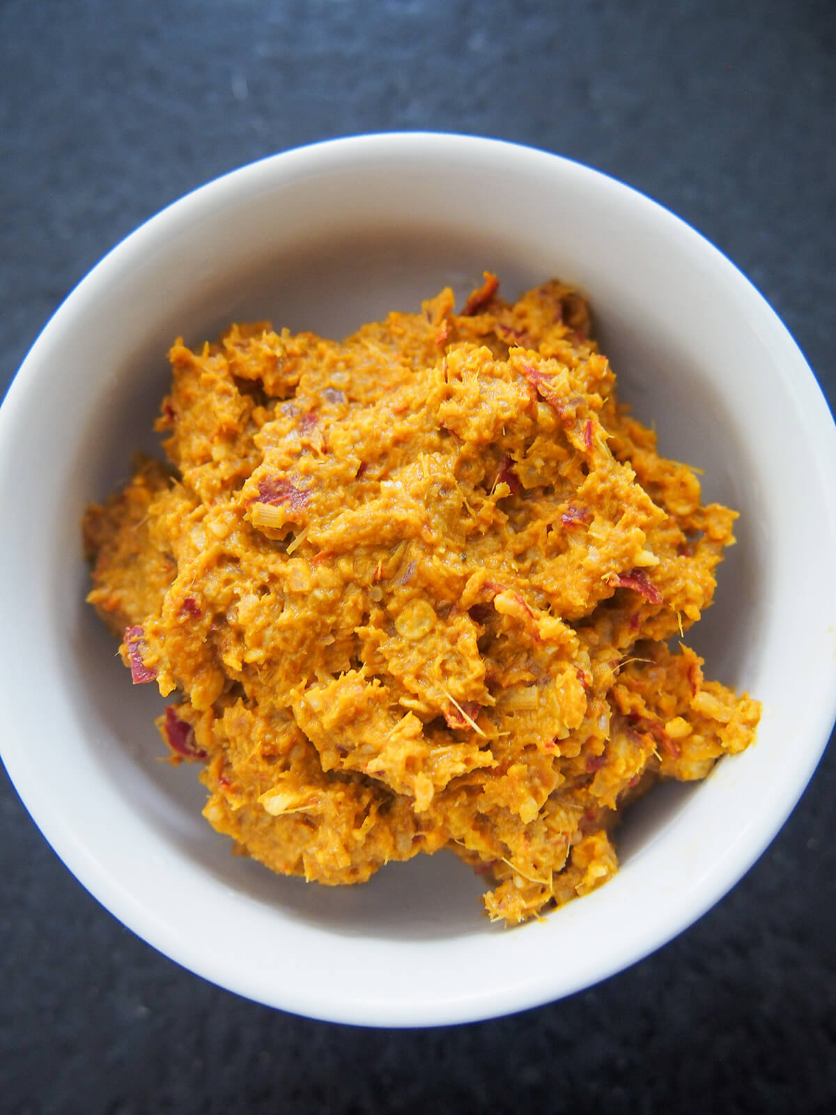 Singapore laksa paste bowl of bright orange laksa paste.