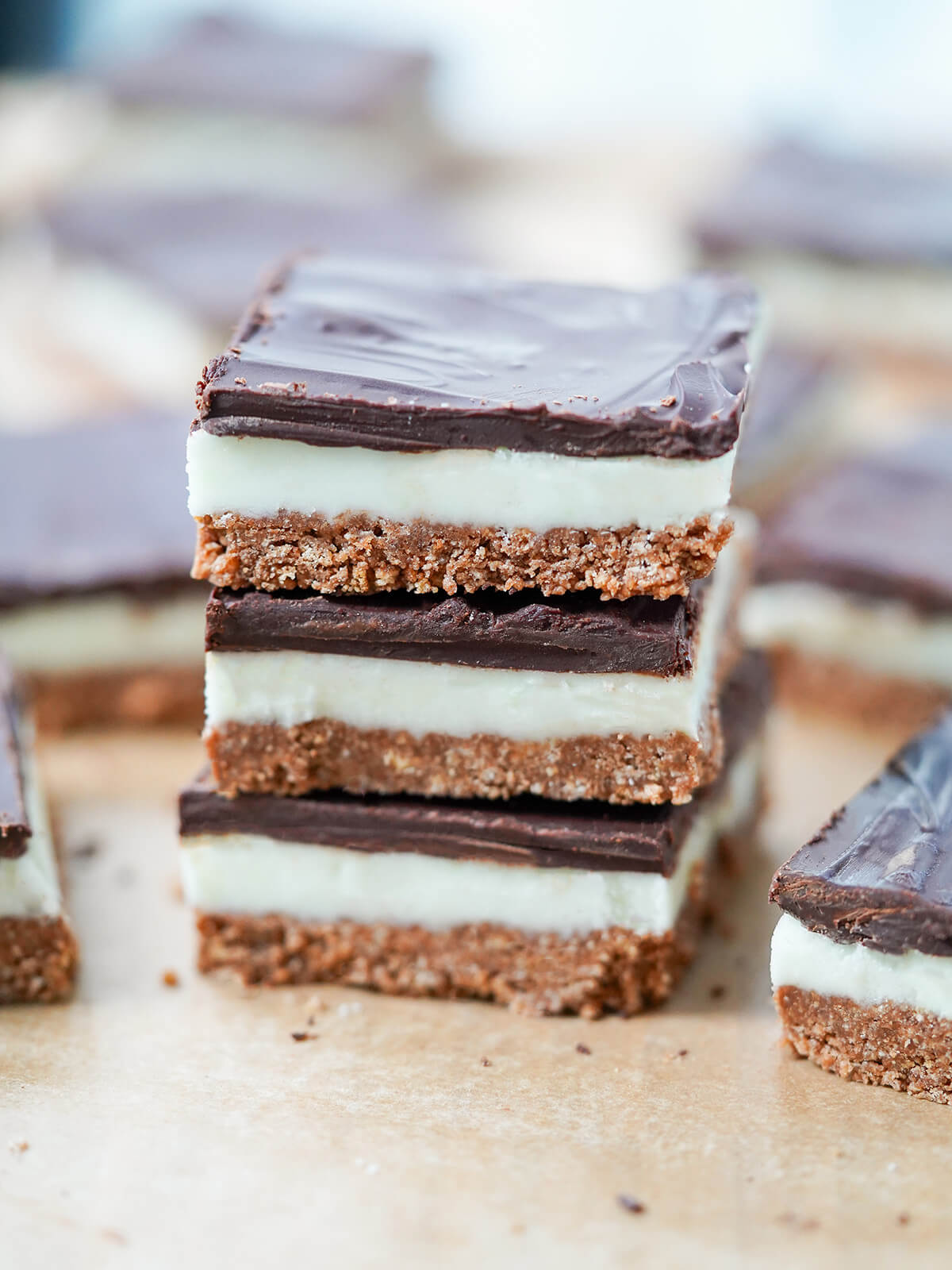 stack of three slices of peppermint slice with more blurred behind.