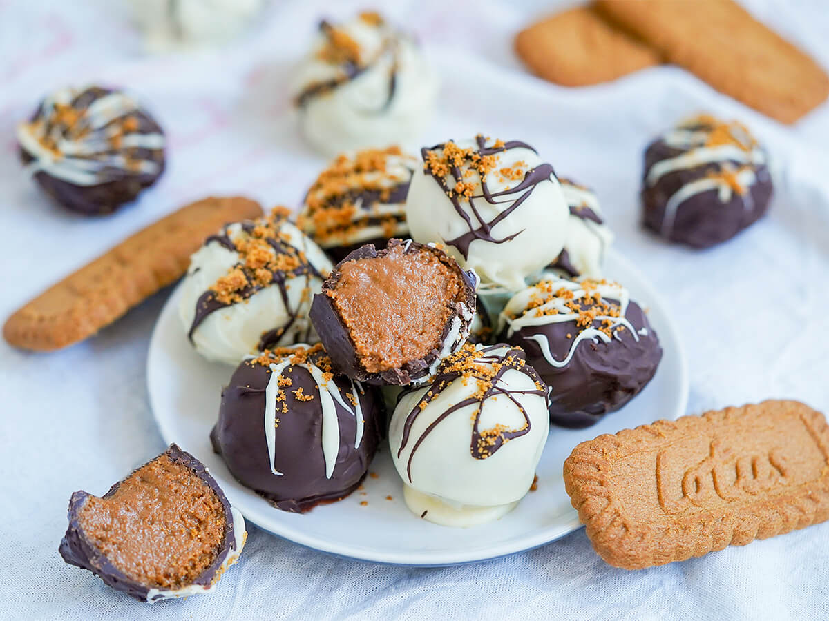 plate of biscoff truffles with a cut half on top and half to one side with cookies to either side.