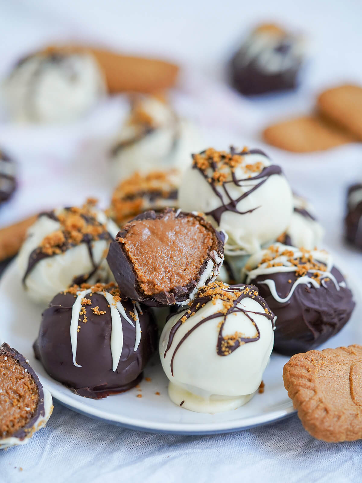 closer view of a cut biscoff truffle resting on top of stack of whole truffles.