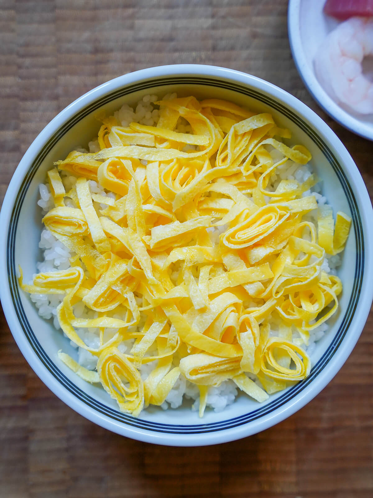 shredded pieces of omelette scattered over bowl of rice.