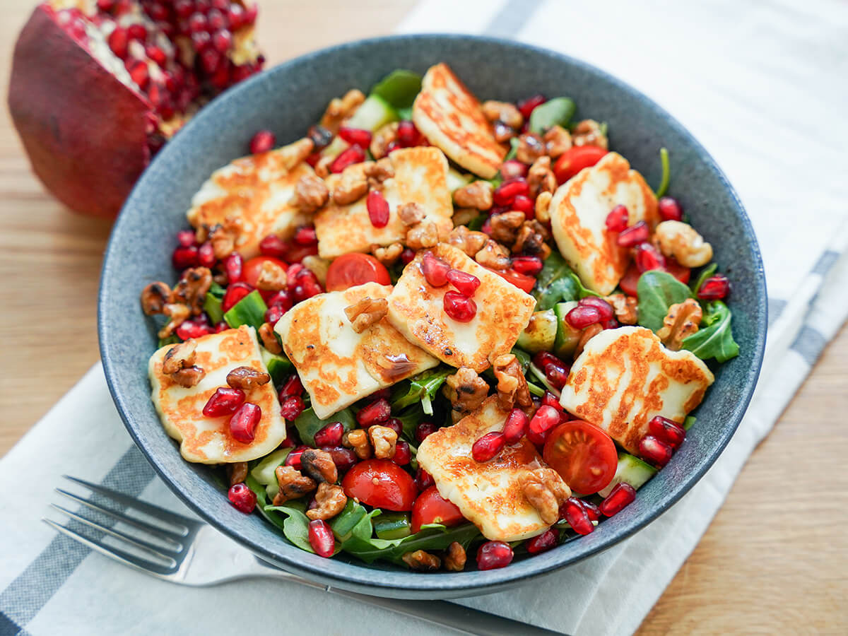 bowl of halloumi pomegranate salad bowl of halloumi pomegranate salad with fork under bowl.