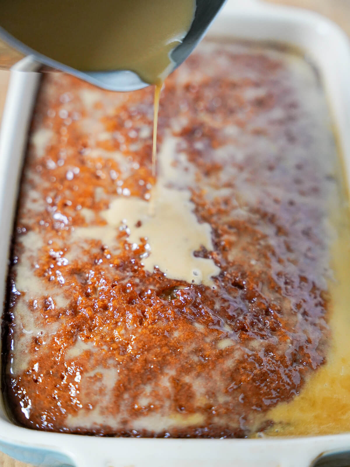 pouring sauce over pudding.