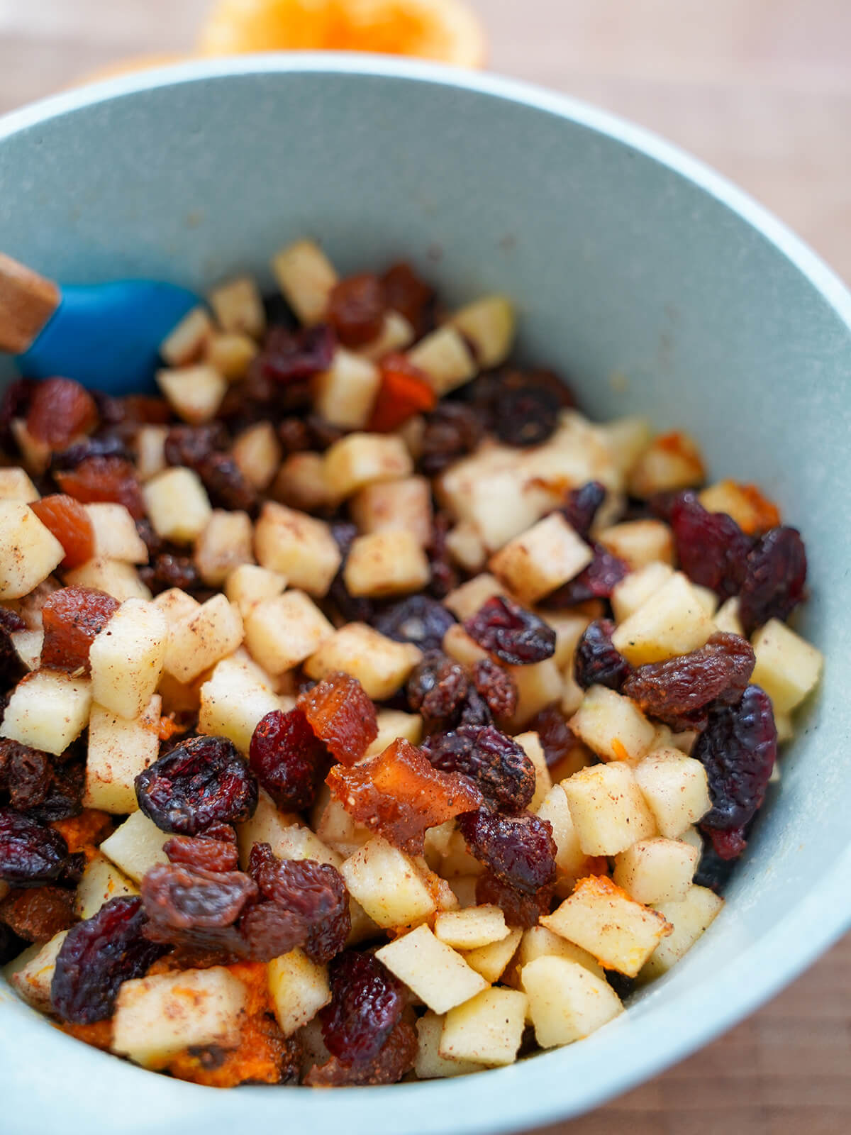 pan with apple and dried fruit in it along with spices and orange before cooking.